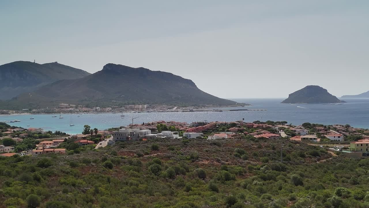 Vista della Sardegna con barche e colline in una giornata di sole