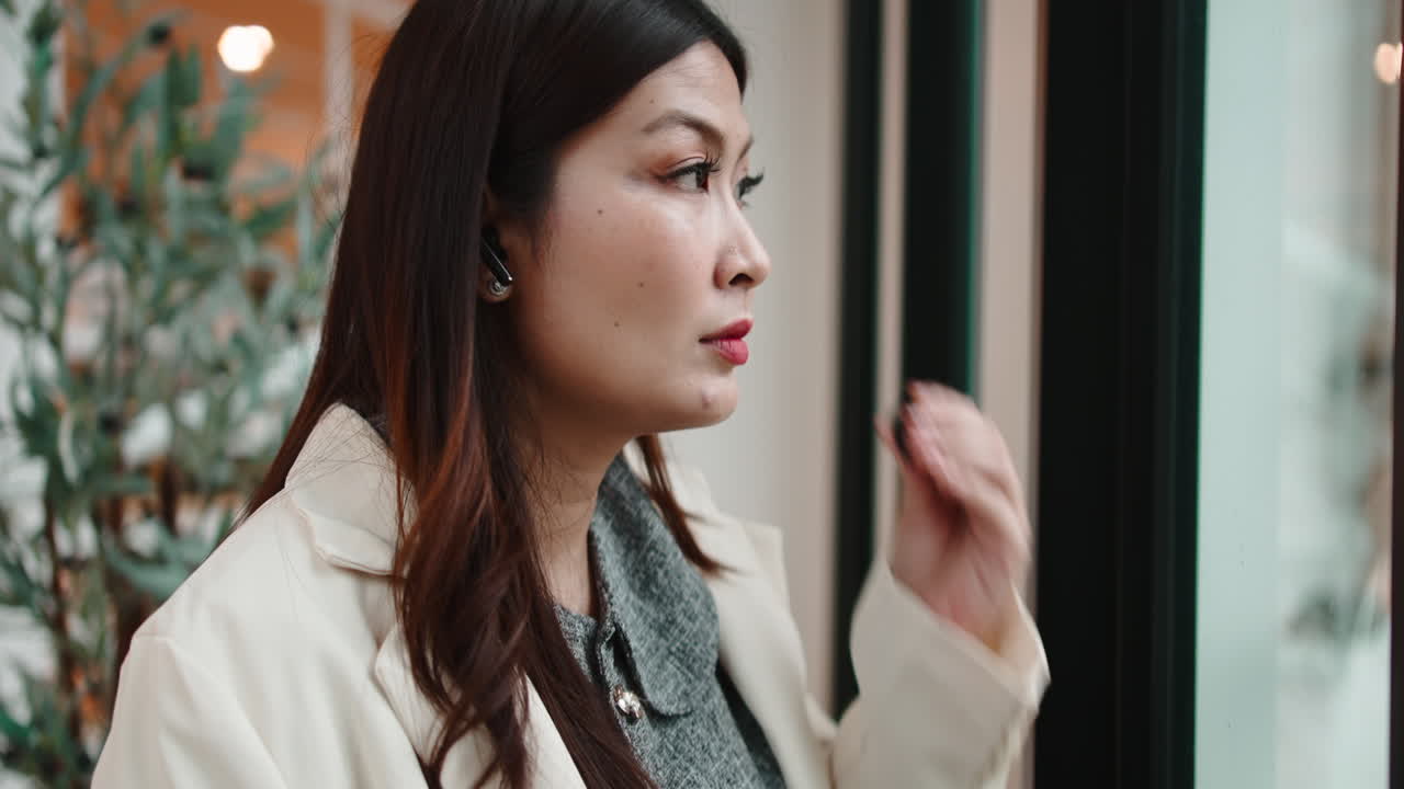 窓から外を眺める女性