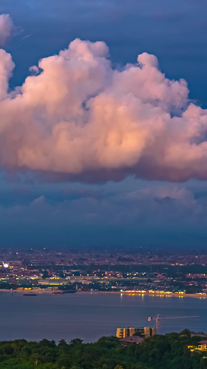 Vertical View Of Waterfront City Under Sunset Clouds. Timelapse