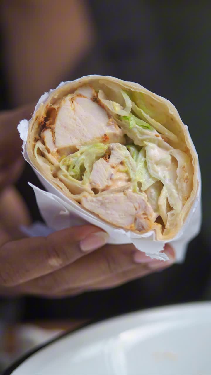 Close-Up of Hands Holding a Delicious Chicken Wrap