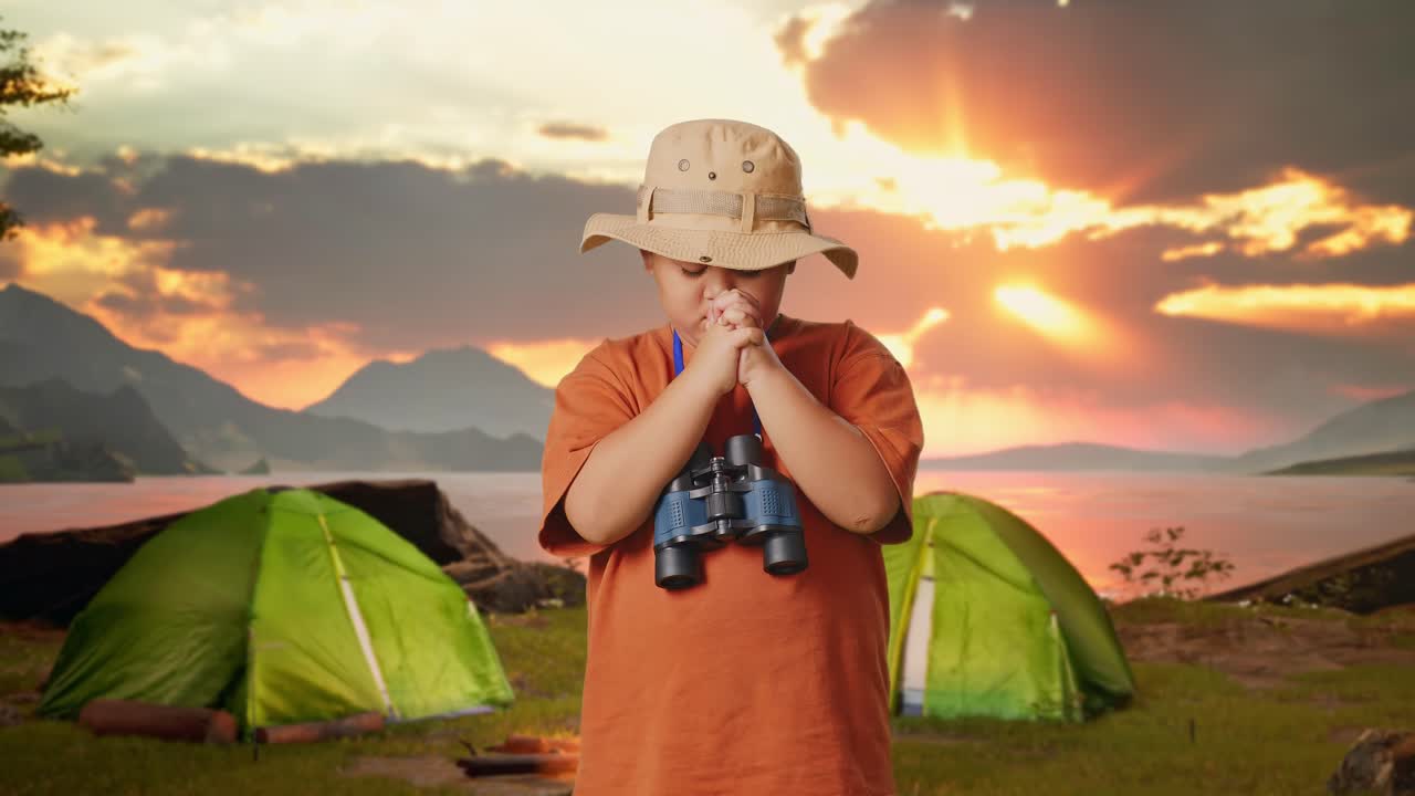 A Child Praying at a Campsite During Sunset