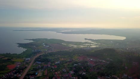 Vista-Panorámica-De-Una-Ciudad-Rural-Situada-A-Lo-Largo-De-Las-Orillas-Del-Lago-Victoria,-Kampala,-Uganda,-áfrica-Oriental---Disparo-Aéreo-De-Drones