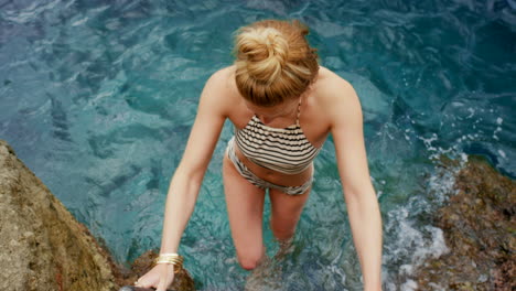 woman in striped bikini leaving the sea