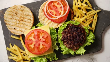 Two-tasty-grilled-home-made-burgers-with-beef--tomato--onion-and-lettuce