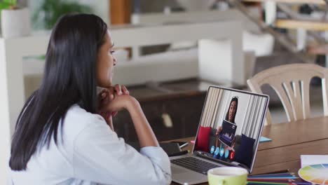 Afroamerikanische-Frau,-Die-Zu-Hause-Einen-Videoanruf-Mit-Einer-Kollegin-Auf-Dem-Laptop-Führt