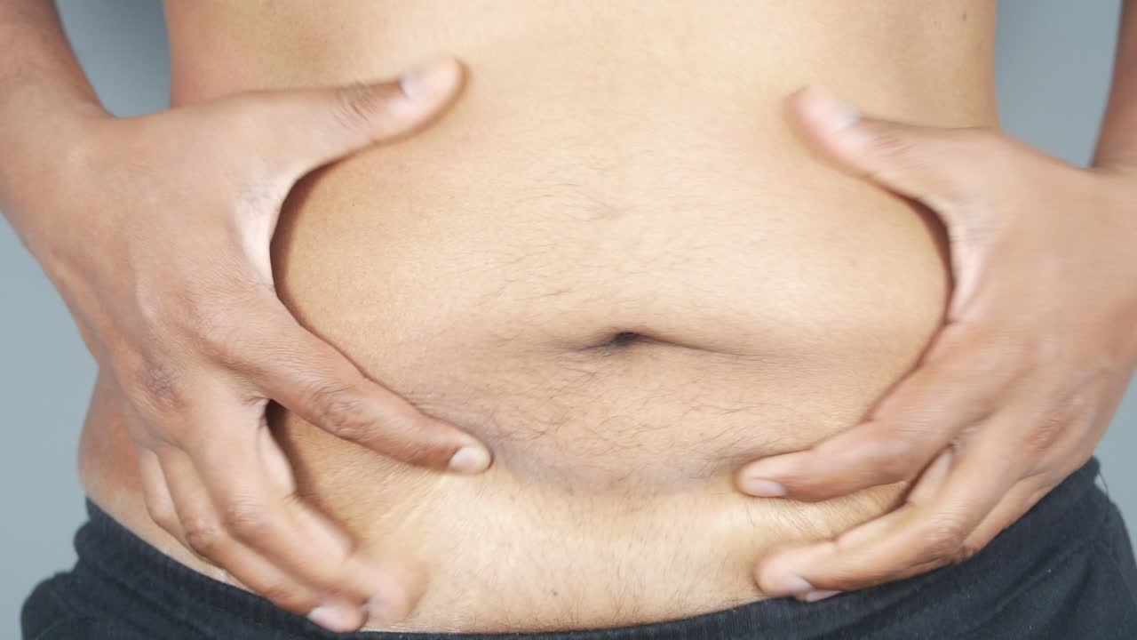hombre comprobando su grasa abdominal