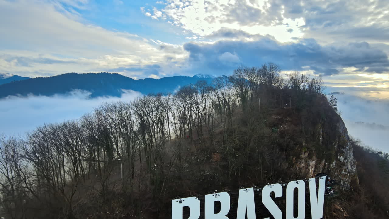 Brasov sign on the top of the hill near the city, bare trees, tourists, low clouds, Romania