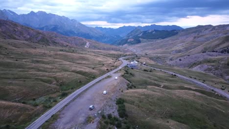 Spanish-Pyrenees,-Spain---Aerial-Drone-View-during-Sunset---Motorhomes-and-Camper-Vans-Sleeping-at-the-Valley