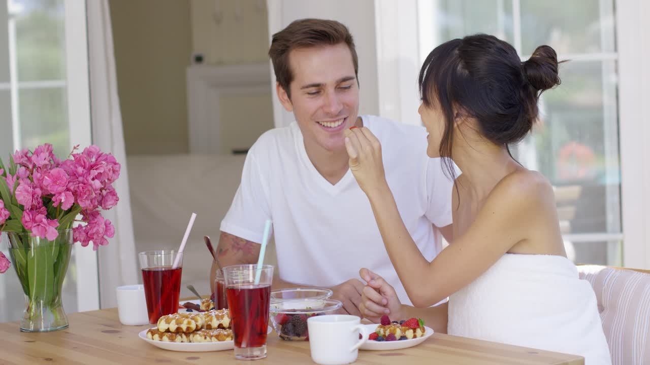 Coppia che si imbocca a vicenda a colazione