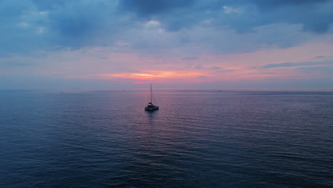 sunset over the ocean with a yacht
