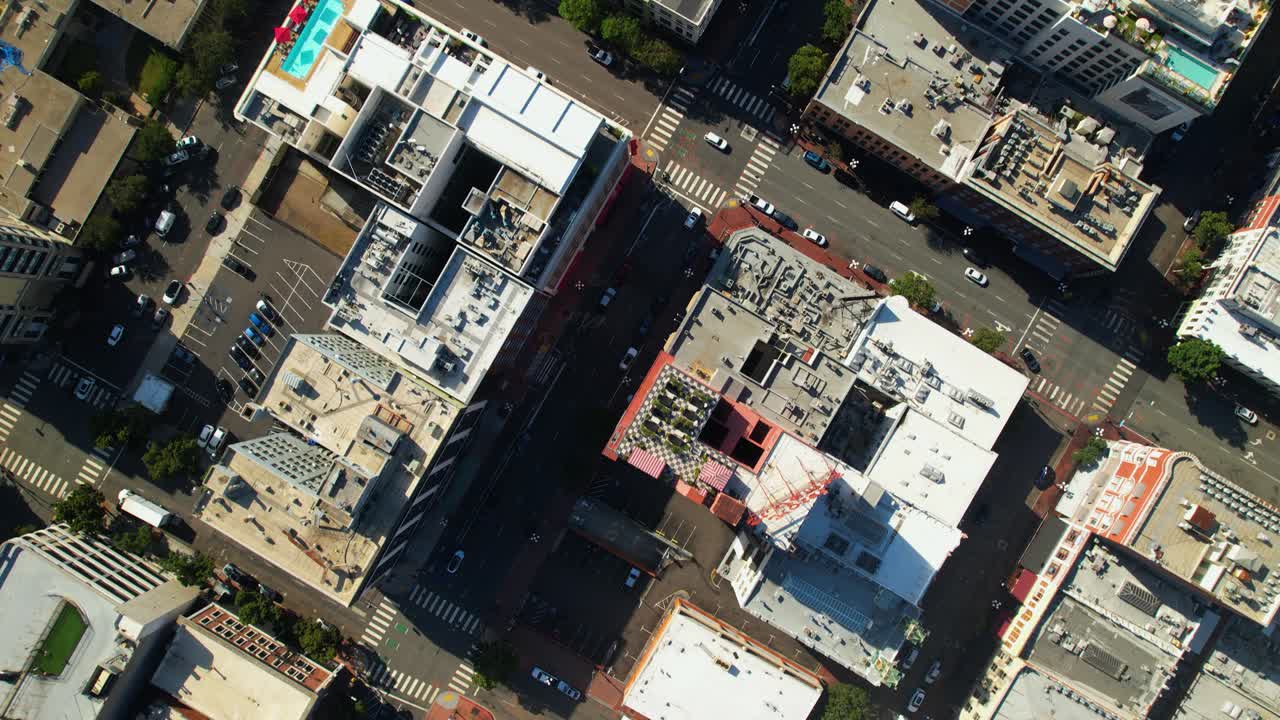Drone voando para leste acima do centro de San Diego às 9h, com uma perspectiva aérea das ruas e edifícios abaixo.