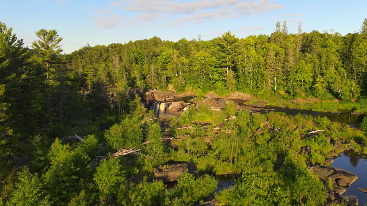 Smukt skovlandskab og flod med små vandfald i Minnesota