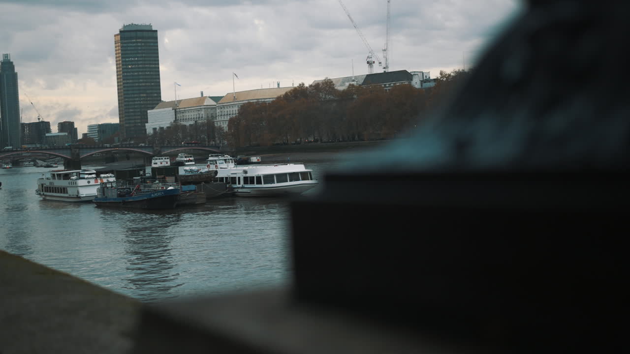 Slider shot of boats moored in the River Thames London city scene
