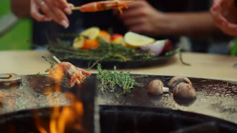 hombre y mujer preparando comida para una fiesta a la parrilla. camarones a la parrilla con hierbas