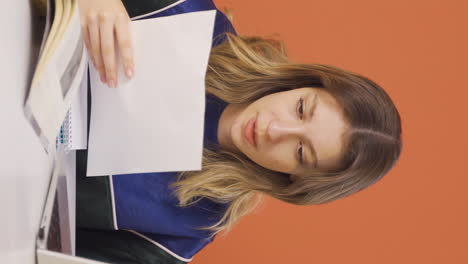 Vertical-video-of-The-young-woman-looking-at-the-documents-is-thoughtful.