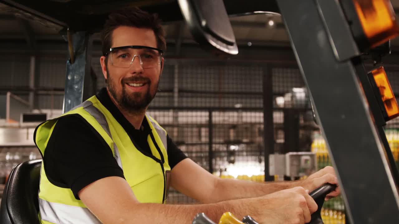 Operaio alla guida di un carrello elevatore in un'industria di imbottigliamento