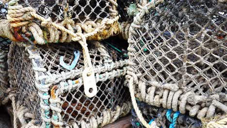 stacked empty fishing harbour industry lobster net baskets closeup dolly left slow