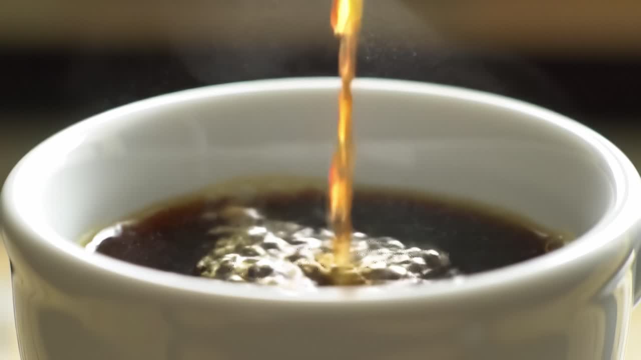 A Close-Up Scene of Coffee Pouring into a White Cup, Capturing the Rich Aroma and Steam Rising in the Air, Highlighting the Comfort and Ritual of Morning Beverages