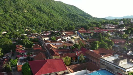 Aerial-view-of-Honda,-Tolima,-Colombia,-small-colonial-town-under-green-hills-by-Magdalena-river,-old-buildings-and-picturesque-landscape,-drone-revealing-shot