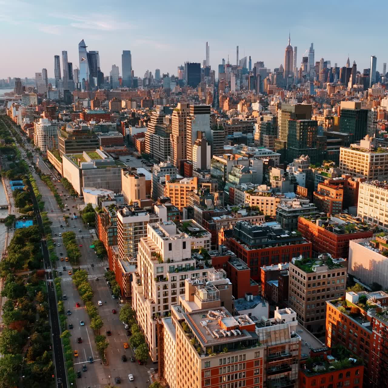 Densely built panorama of New York at sunset. Lively highway on the waterfront near the river. Top view
