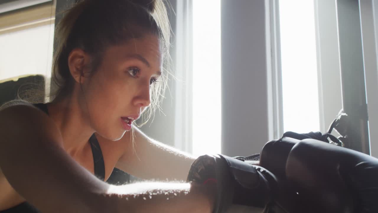 체육관 에서 박스 훈련 을 한 후 휴식을 취하고 있는 건강 하고 피곤 한 백인 여성 의 영상