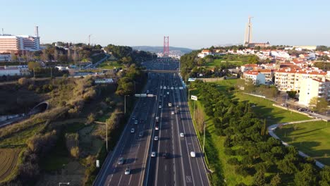 drone shot flying backwards over a highway with lisbon in the background