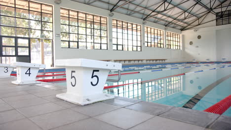 indoor swimming pool with starting blocks and lanes ready for competition, copy space