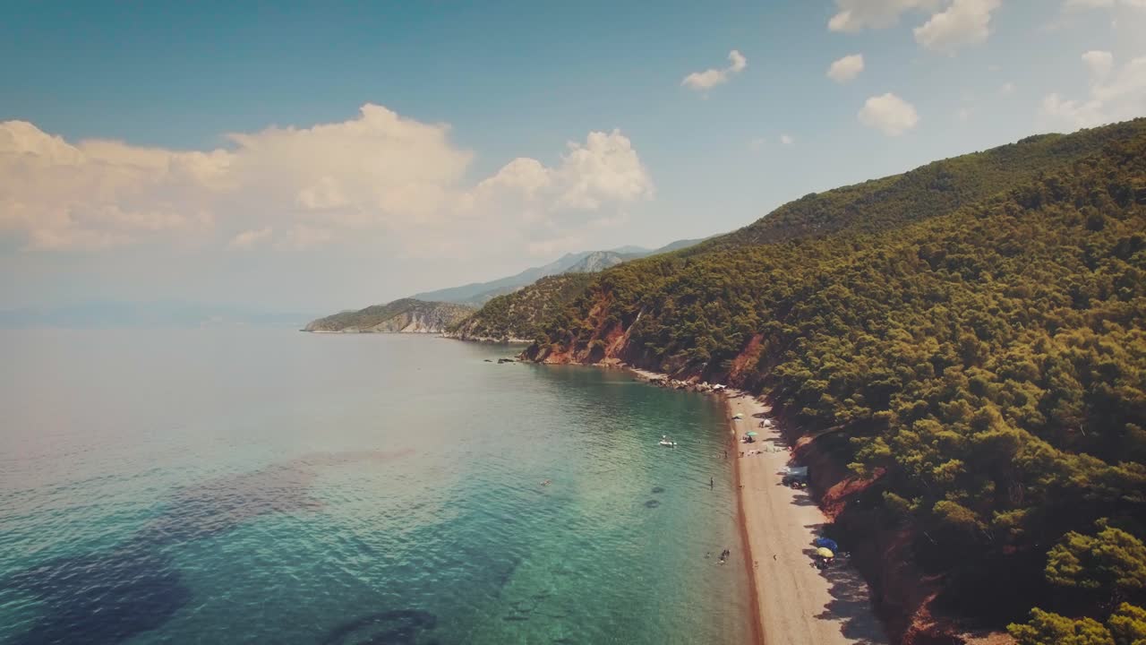 aerial footage of an exotic beach with crystal clear turquoise waters in Greece at summer 7