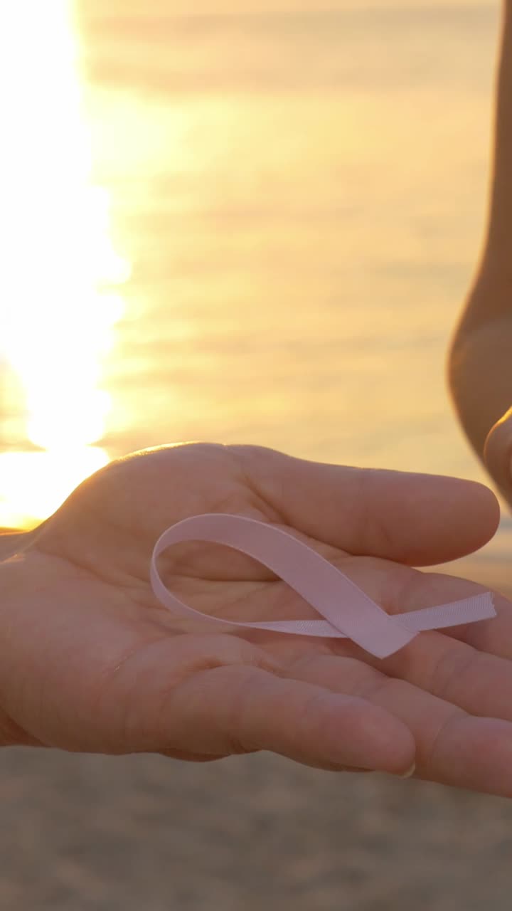Breast Cancer Awareness Ribbon on Hand at Sunset