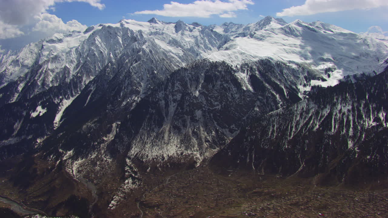vuelo aéreo sobre un río y cimas de montañas, cubiertas de nieve
