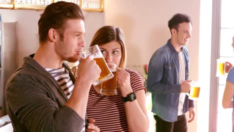 pareja interactuando mientras tienen un vaso de cerveza