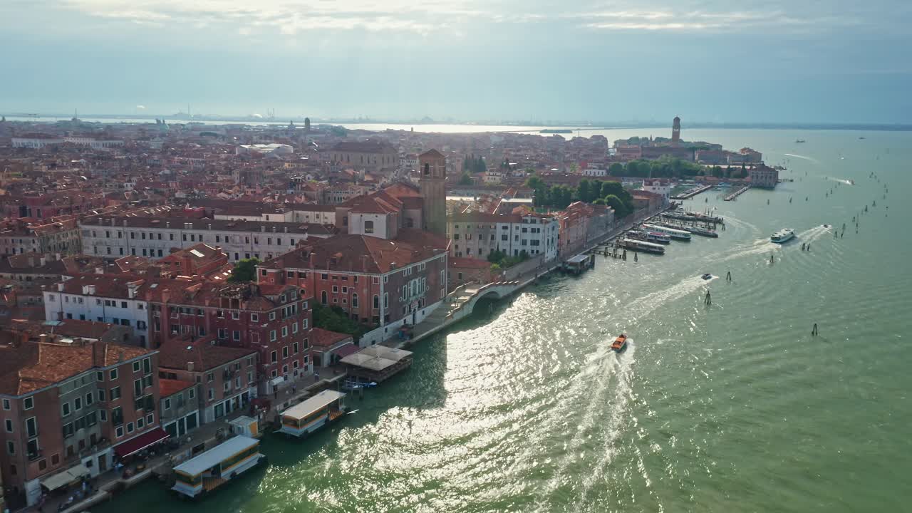 Santa maria assunta church in venice with boats on glistening water, aerial view