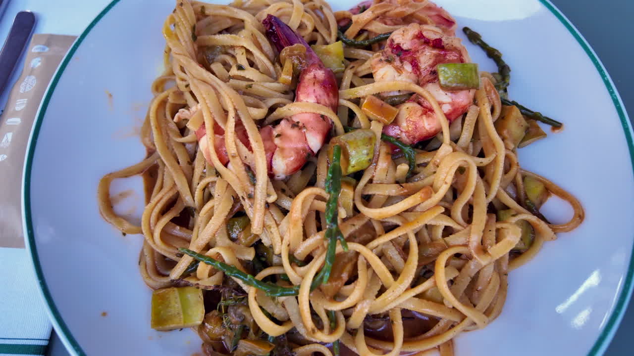 Close up of seafood pasta on a white plate at a restaurant