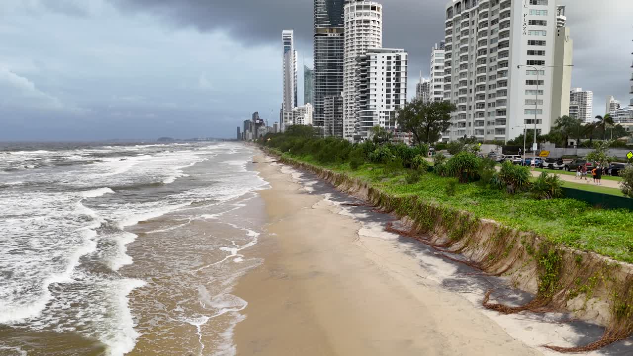 Drone footage captures severe beach erosion and turbulent waves along Gold Coast, Australia, during Cyclone Alfred. Overcast skies enhance dramatic atmosphere