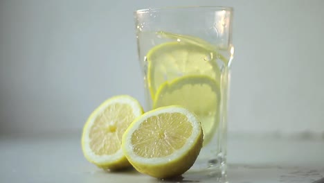 slice lemon fruit in glass of water on table with white background stock footage