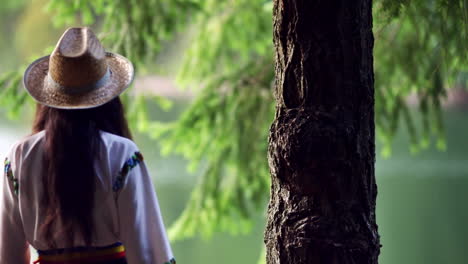 Romanian-girl-walks-through-the-forest-and-touching-the-tree-bark