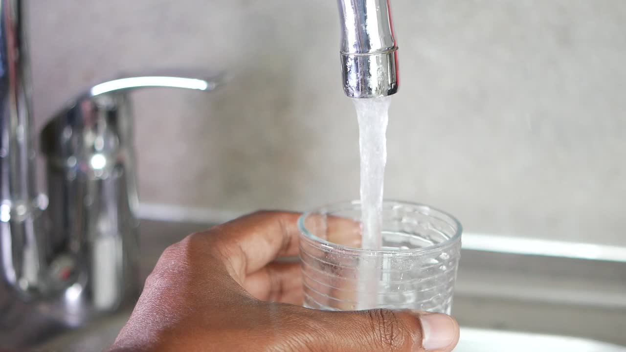 llenando un vaso con agua de un grifo