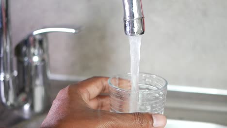 llenando un vaso con agua de un grifo