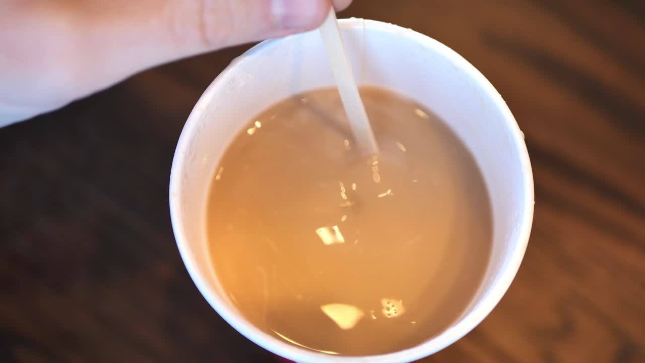 뜨거운 커피나 차를 넣은 컵을 휘젓는 백인 남자의 커피숍 카페에서 찍은 클립