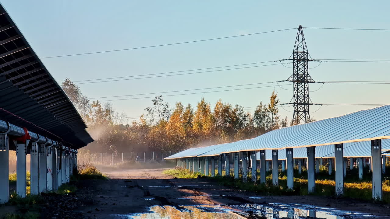 Solar panels and power lines on early misty morning, static view