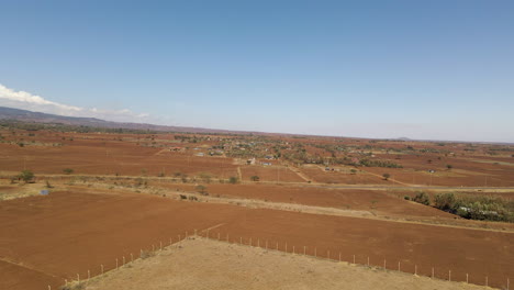 jib up of an arid landscape in rural kenya with a small village in the distance