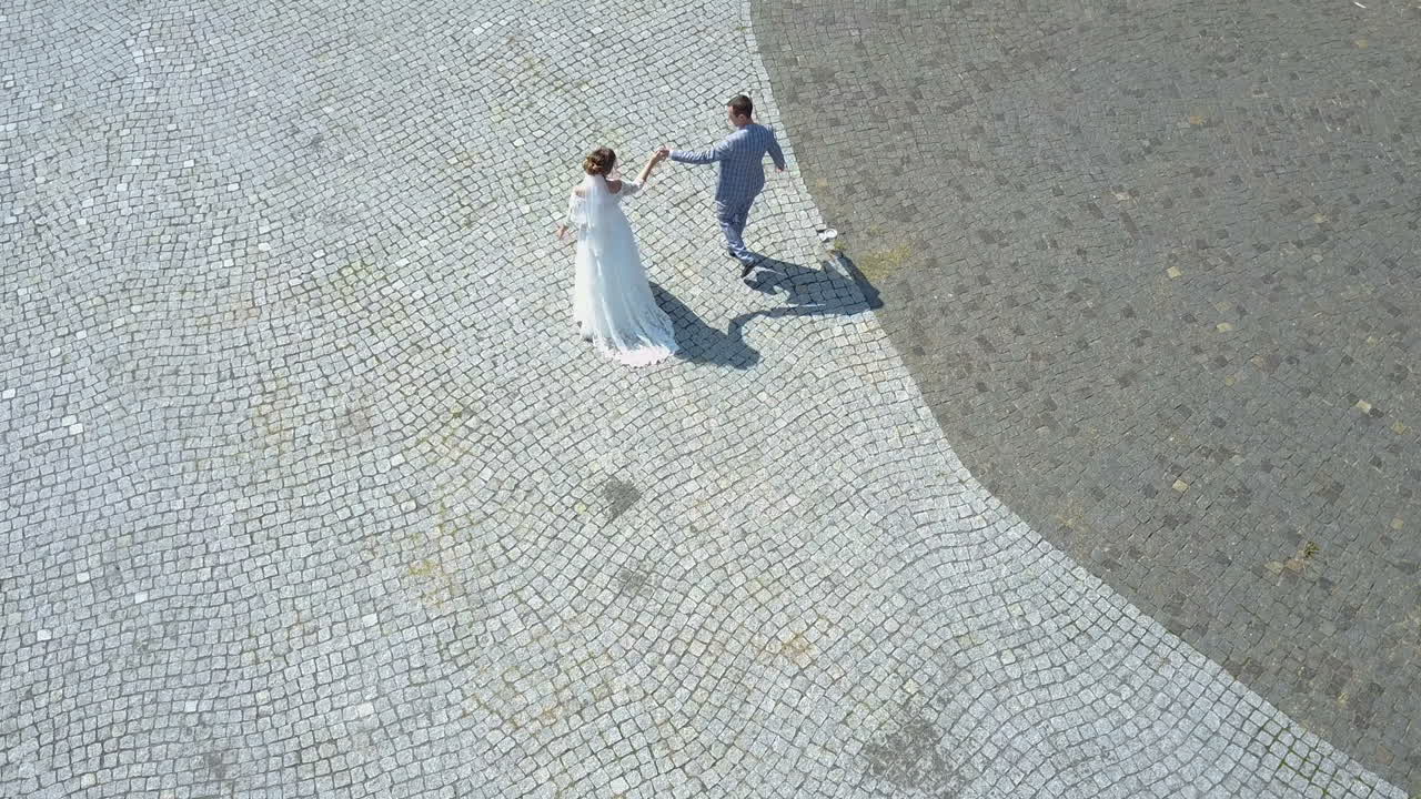 Aerial view. Wedding couple walks on old european city street. Just married