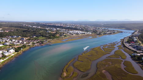 una lancha rápida con un esquiador acuático corriendo por el pintoresco río goukou en stilbaai, vista de avión no tripulado