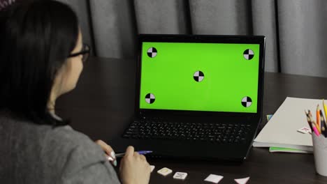 maestra haciendo llamada de video de educación a distancia en línea en la pantalla verde de la computadora portátil