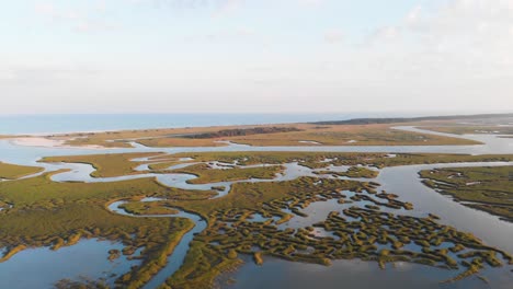 Tracking-drone-footage-over-wetlands-towards-a-beach-at-sunset-in-SC