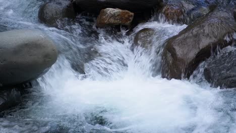 detail shot: a river, with water running and falling over levigated rocks