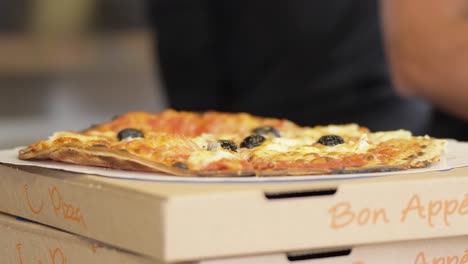 Close-up-of-hot-tasty-pizza-ready-for-packaging-at-shop