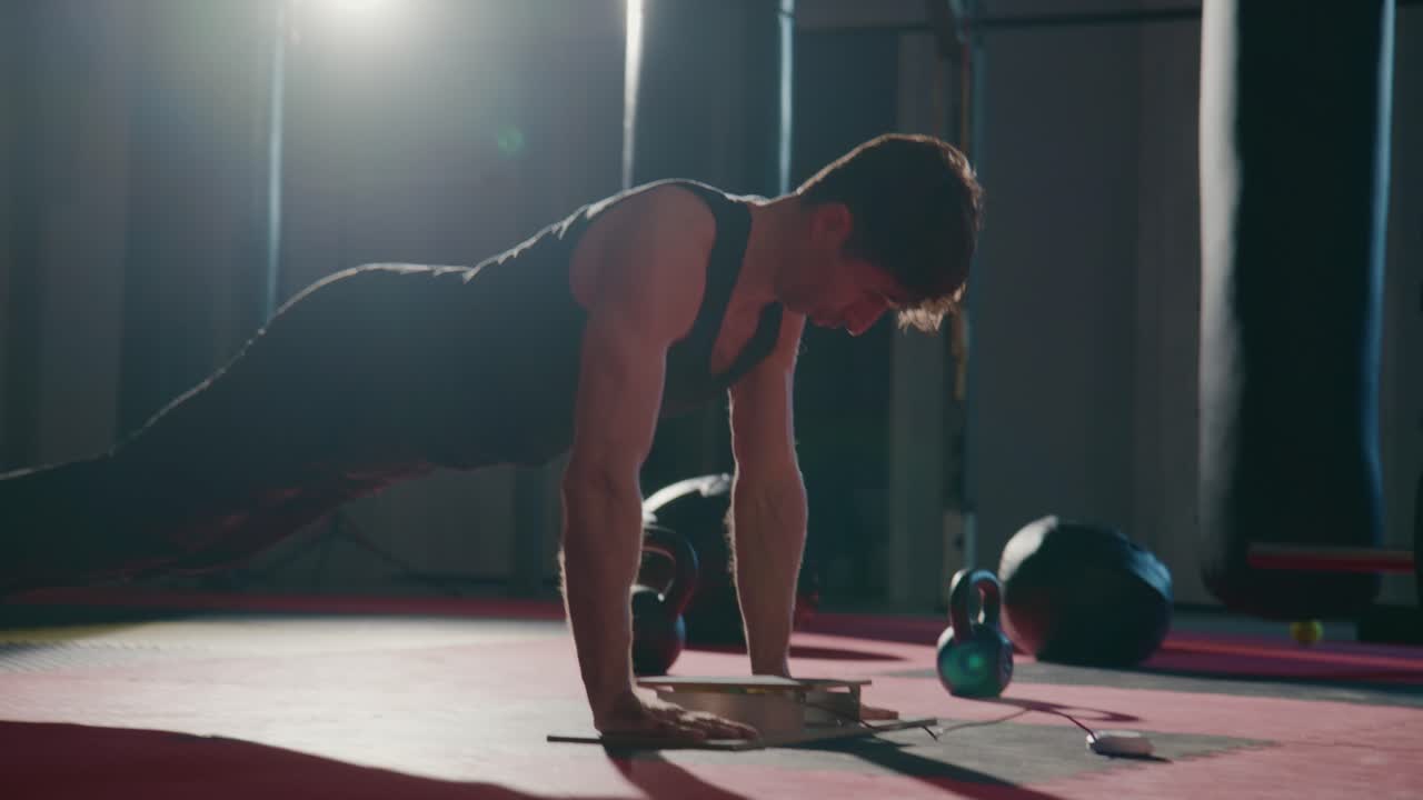 Determined Man Doing Push-ups in a Dark Gym