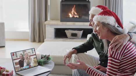 Two-happy-caucasian-couples-having-christmas-laptop-video-call,-slow-motion