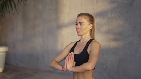 Entrenadora-De-Yoga-Hace-Gesto-De-Namaste-Con-Las-Manos-En-El-Interior-Por-La-Mañana